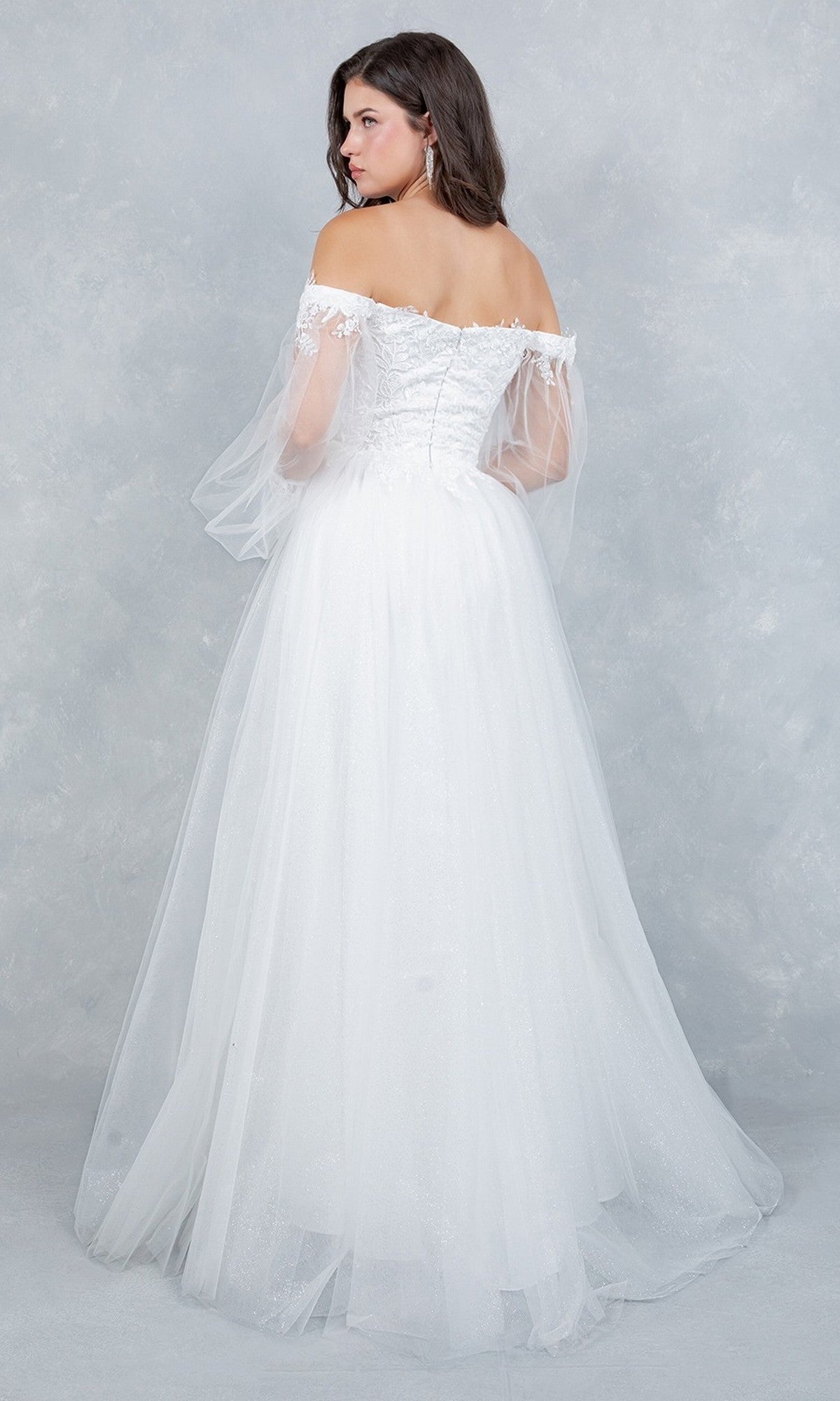 A woman stands with her back to the camera against a light gray background, wearing the Cinderella Couture 4233 long formal dress—an off-the-shoulder white gown featuring an embroidered bodice and a flowing tulle skirt in a classic A-line silhouette.